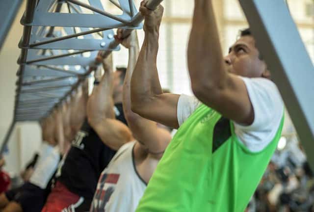 Athlete performing chin up test on overhead bar