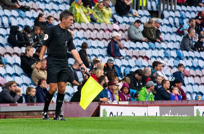 Football assistant referee running along touchline
