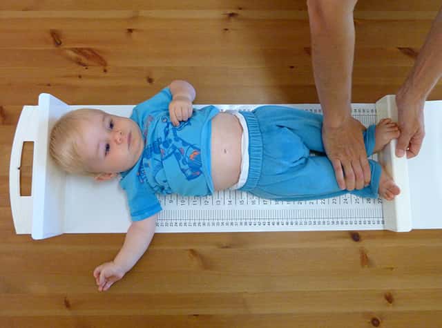 Baby being measured using a length scale (infantometer)