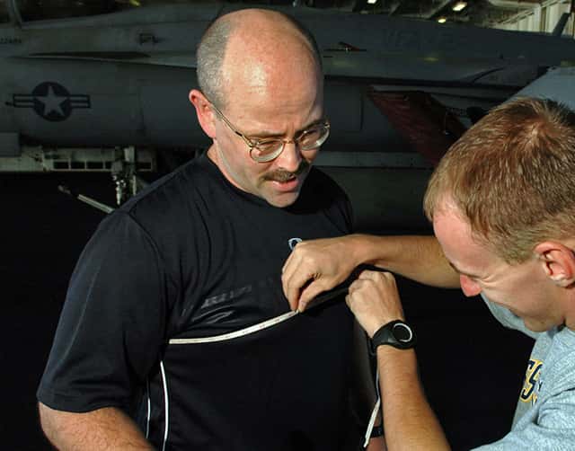 measuring chest girth with tape measure at sternum level
