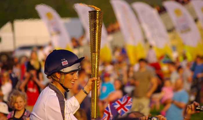 English equestrian Zara Phillips carrying the torch on horseback