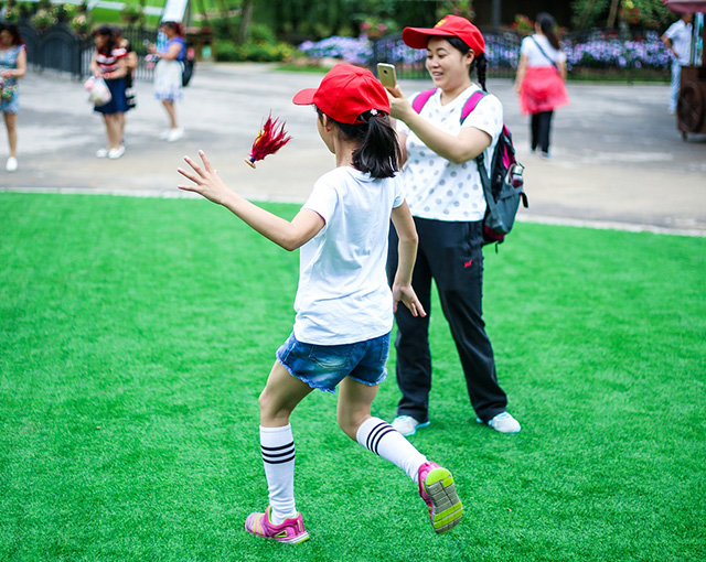 a kid trying to keep the Jianzi "shuttlecock" in the air