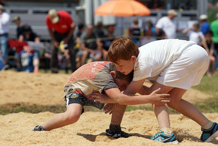 boys wrestling in sand